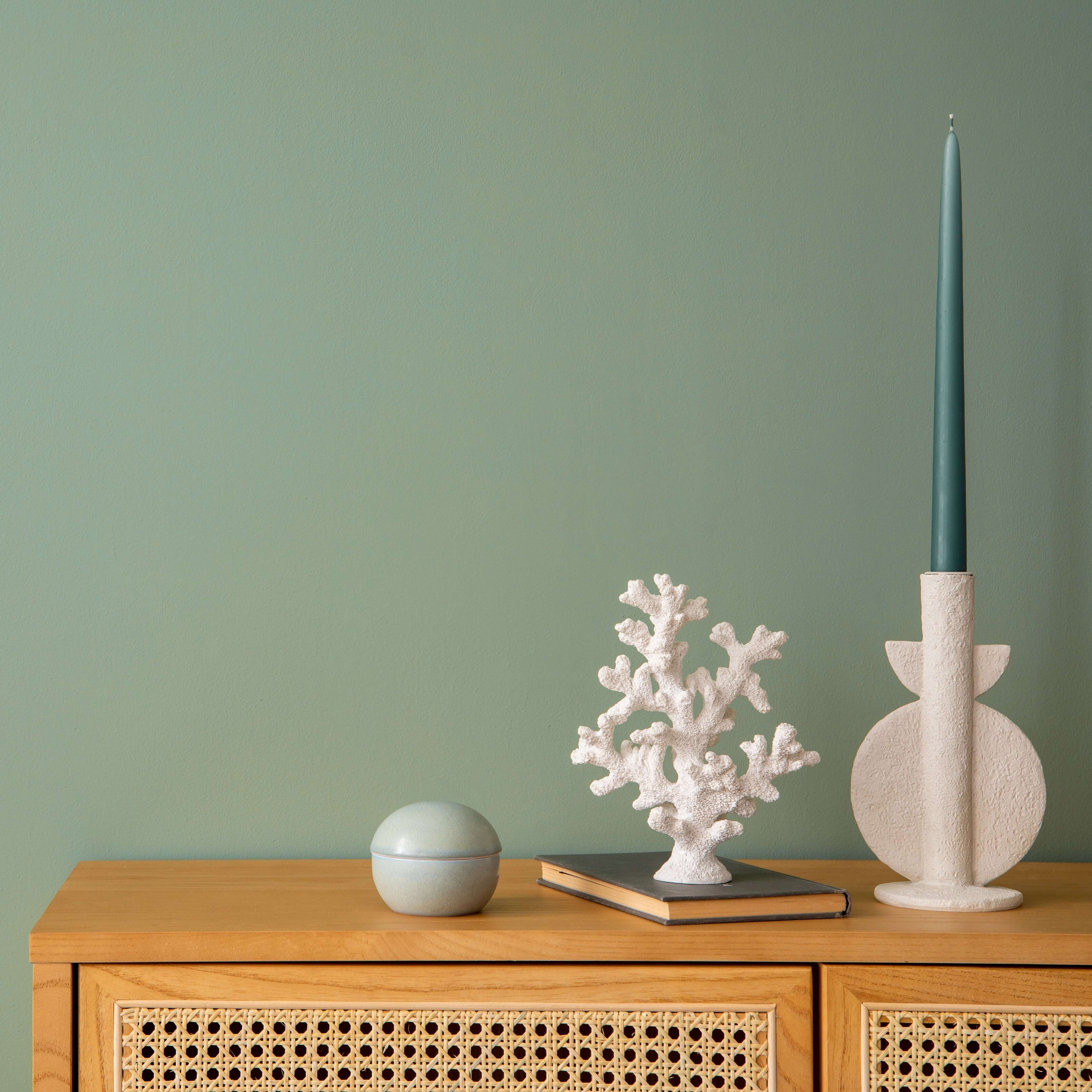 Wandfarbe Salbeigrün No. 640 Design Collection auf einer Wand mit dekorativen Elementen auf einem Sideboard.